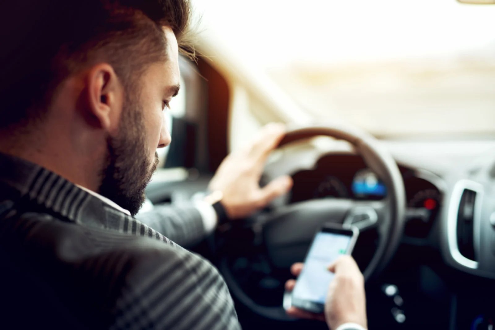 image of driver on phone, showing the importance of distracted driving awareness month