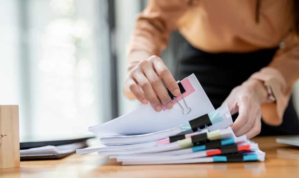 Woman's hands going through MVRs for insurance paperwork