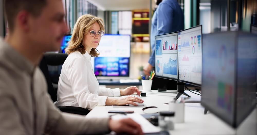 Insurance data analyst reviewing telematics data on computer